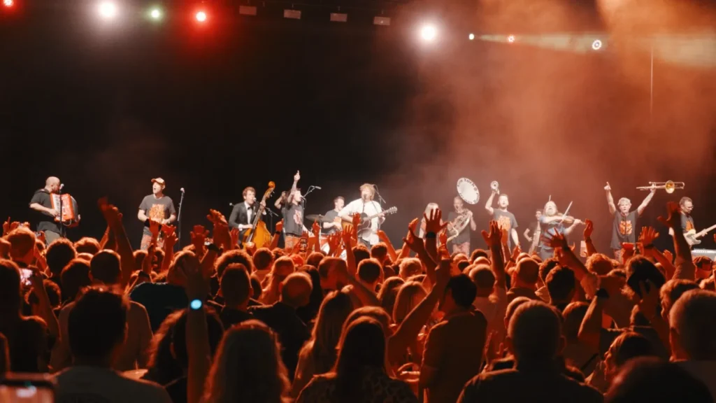 The band with New York Brass Band on stage, the crowd's hands in the air