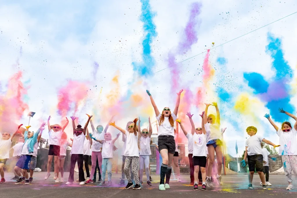 Children throwing coloured powder at Tadcaster Carnival