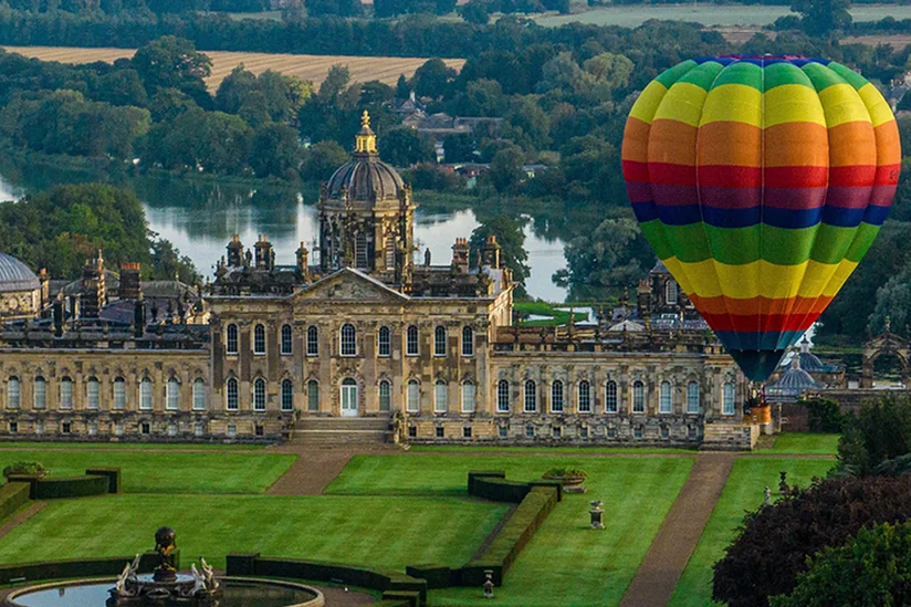 A hot air balloon rising beside Castle Howard