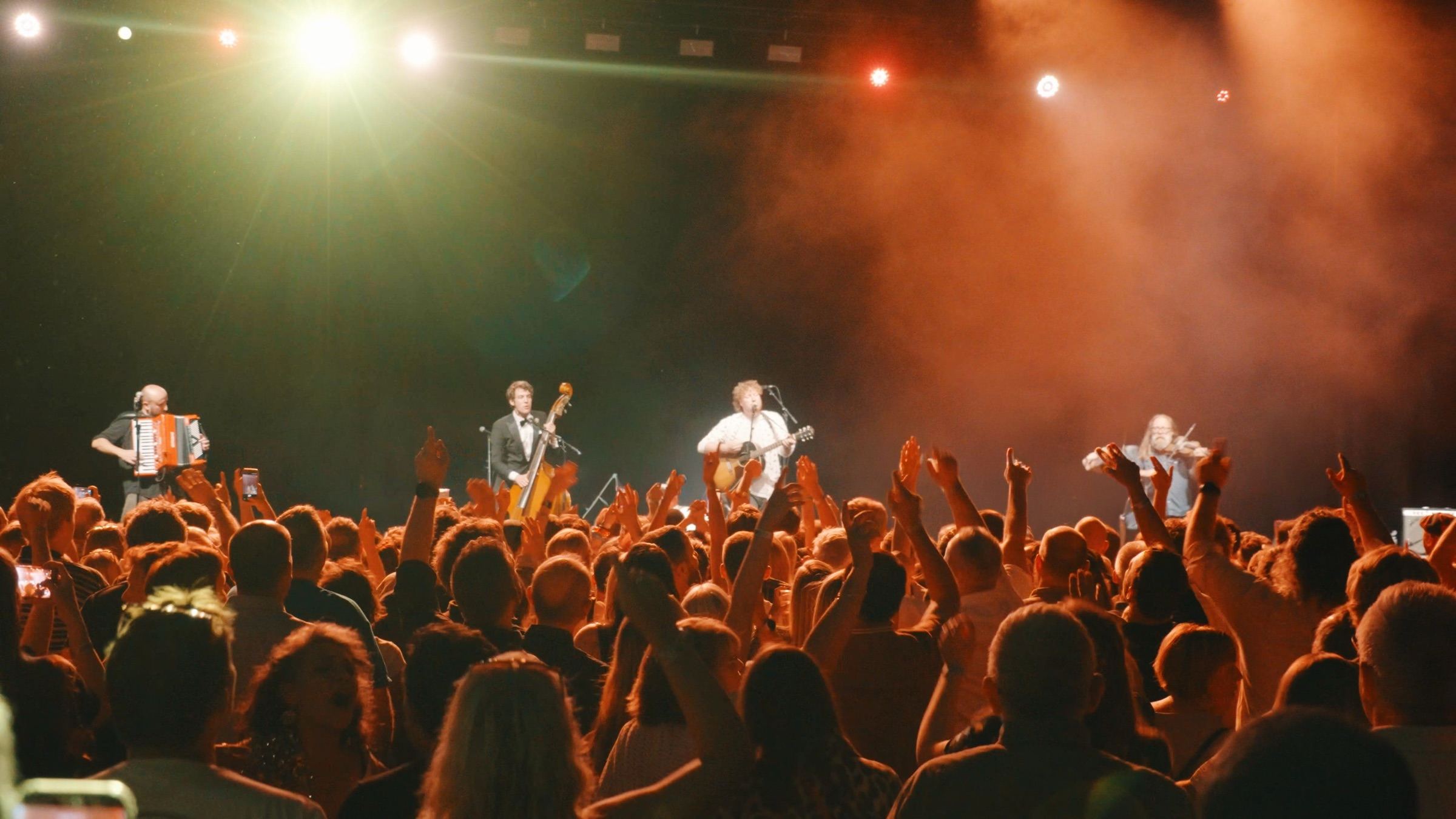 Hyde Family Jam playing to a packed crowd with their hands in the air